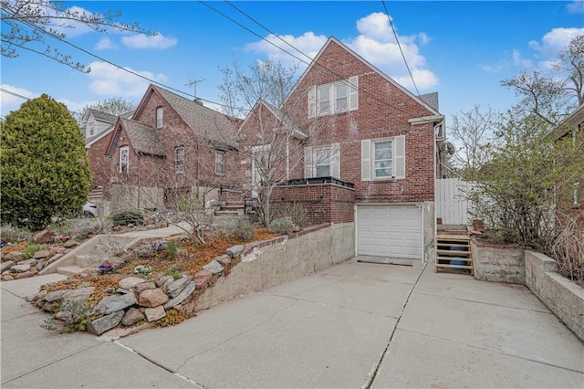 view of front of home with brick siding, driveway, a garage, and stairs