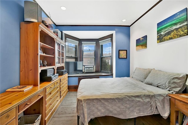 bedroom with wood finished floors and ornamental molding