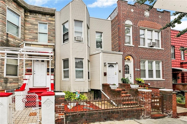multi unit property featuring a fenced front yard and cooling unit
