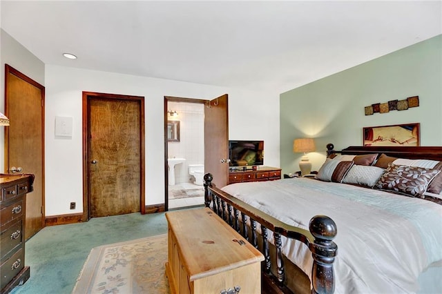 carpeted bedroom with ensuite bath and baseboards