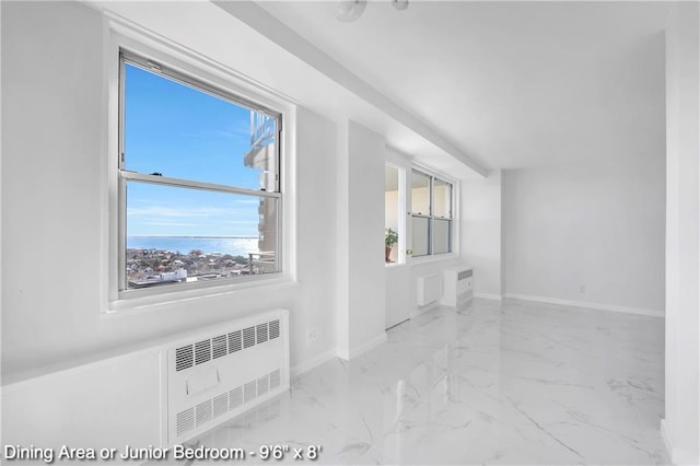 35 Seacoast Ter Unit 16D, Brooklyn, NY 11235 - unfurnished room featuring radiator heating unit, marble look tile flooring, plenty of natural light, and baseboards