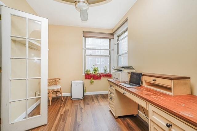 home office featuring wood finished floors, ceiling fan, and baseboards
