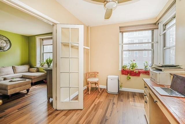 entryway featuring light wood-style flooring, ceiling fan, baseboards, and lofted ceiling
