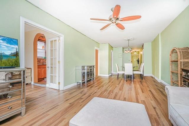 8701 Shore Rd Unit 421, Brooklyn, NY 11209 - living room with wood finished floors, ceiling fan, baseboards, and arched walkways