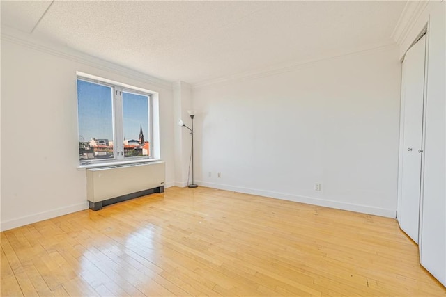 unfurnished bedroom with baseboards, ornamental molding, and light wood-style floors