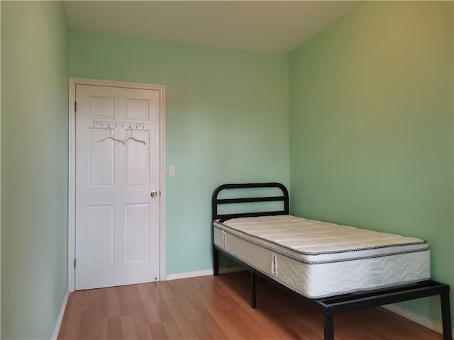 bedroom featuring wood finished floors and baseboards