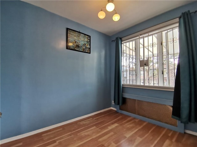 unfurnished room with wood finished floors and baseboards