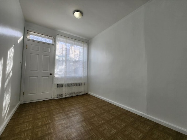 foyer featuring radiator and baseboards