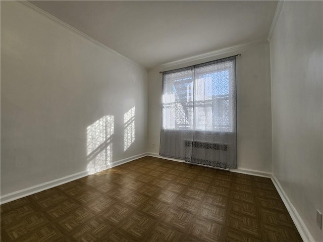 empty room featuring baseboards, radiator heating unit, and ornamental molding