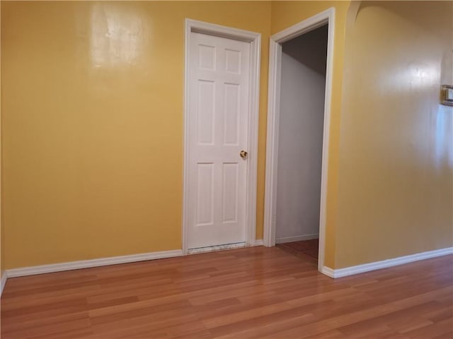 empty room with light wood-style floors and baseboards