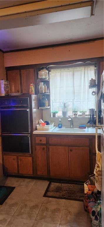 750 Warwick St, Brooklyn, NY 11207 - kitchen featuring black oven, brown cabinetry, a sink, light countertops, and a warming drawer