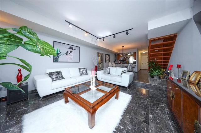 living area with track lighting and marble finish floor