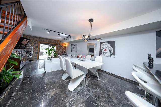 dining space with rail lighting and marble finish floor