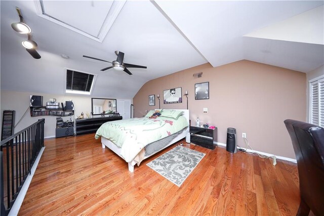 bedroom with lofted ceiling, baseboards, a ceiling fan, and wood finished floors