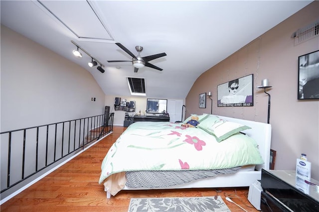 bedroom featuring vaulted ceiling, a ceiling fan, wood finished floors, and visible vents