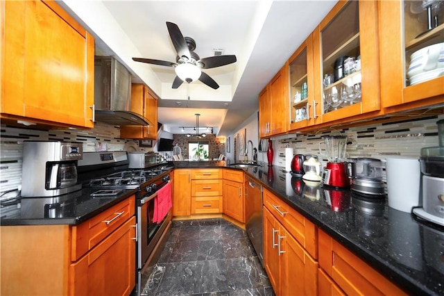 kitchen with wall chimney range hood, decorative backsplash, and appliances with stainless steel finishes