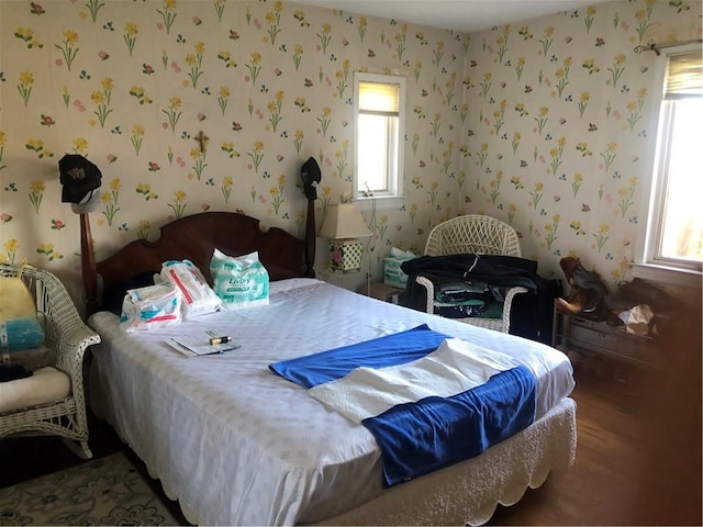 bedroom with wallpapered walls and wood finished floors