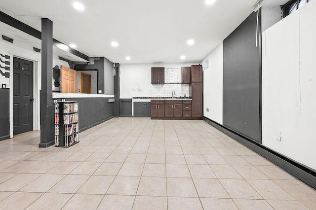 kitchen featuring dark brown cabinetry, recessed lighting, backsplash, light countertops, and light tile patterned floors