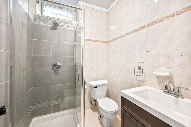 bathroom with a shower stall, vanity, toilet, and tile walls