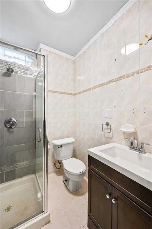bathroom with tile patterned flooring, toilet, a stall shower, and tile walls