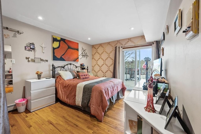 bedroom featuring a baseboard heating unit, light wood-style flooring, access to exterior, and recessed lighting