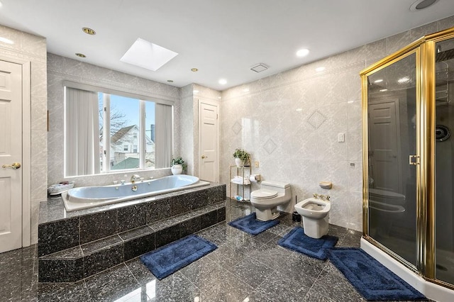 bathroom with toilet, tile walls, granite finish floor, a bidet, and a skylight