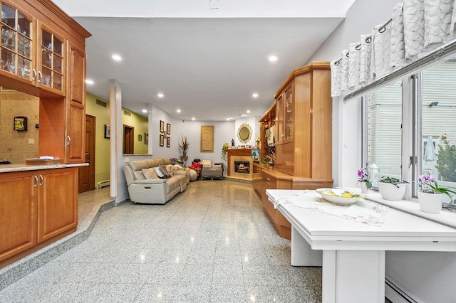 recreation room featuring granite finish floor, visible vents, a lit fireplace, and recessed lighting