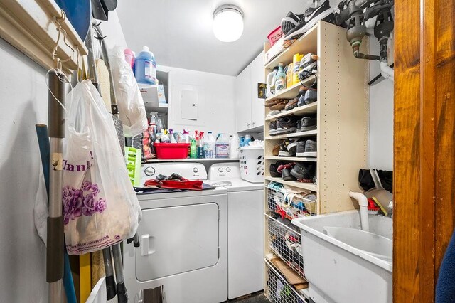 laundry room with washing machine and clothes dryer, cabinet space, and a sink