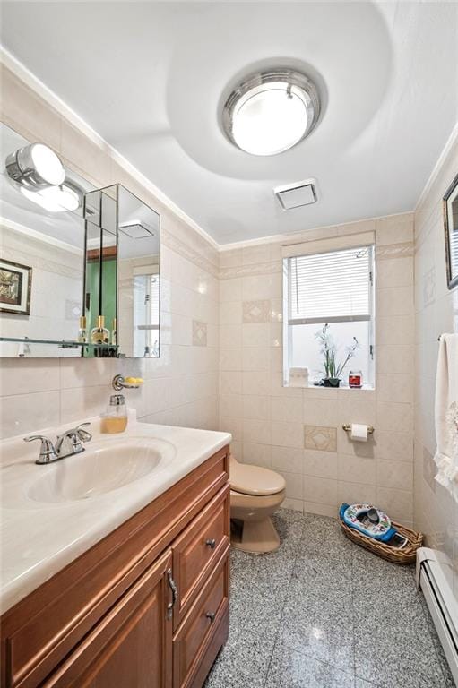 bathroom with toilet, tile walls, granite finish floor, vanity, and a baseboard radiator