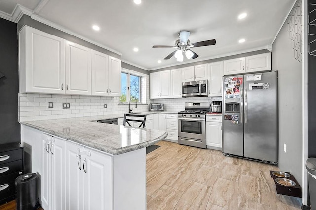 kitchen featuring a peninsula, white cabinetry, appliances with stainless steel finishes, and ornamental molding