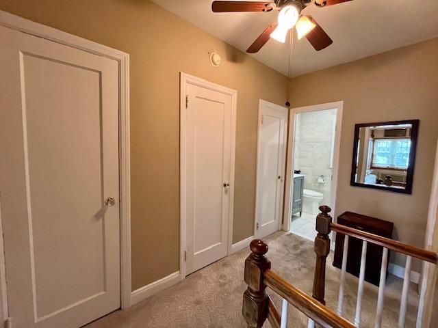hall with light colored carpet and baseboards