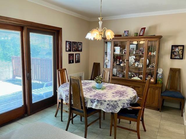 dining room featuring a chandelier, crown molding, and light tile patterned floors