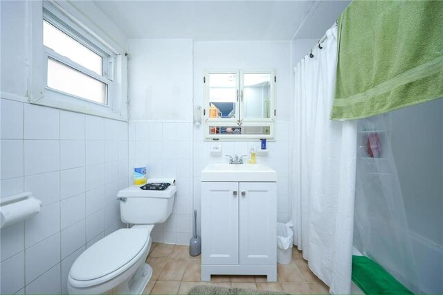 2939 Brighton 3rd St, Brooklyn, NY 11235 - full bath with tile patterned flooring, vanity, curtained shower, toilet, and tile walls