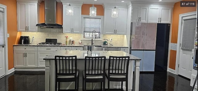 kitchen with wall chimney exhaust hood, a sink, white cabinets, and recessed lighting