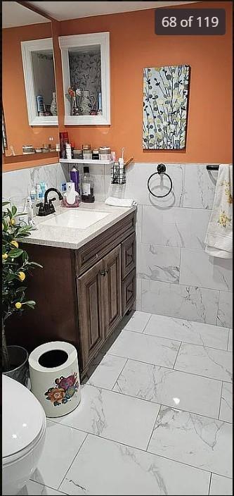 bathroom featuring marble finish floors, vanity, and toilet
