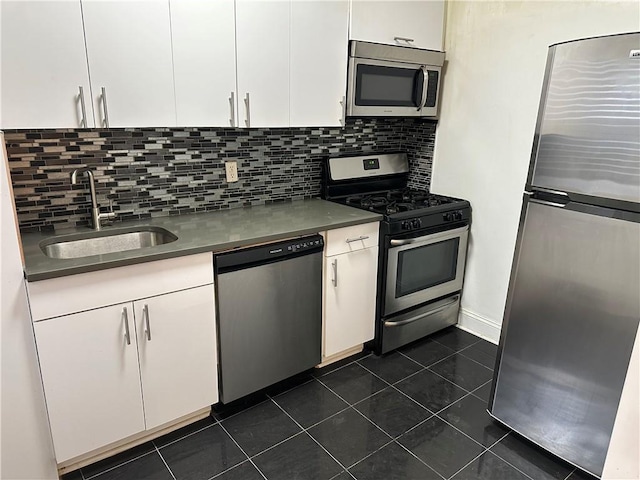 130 Bay Ridge Parkway Unit 4A, Brooklyn, NY 11209 - kitchen with stainless steel appliances, a sink, white cabinets, dark tile patterned flooring, and backsplash