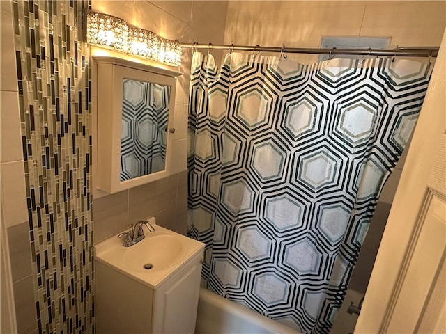 130 Bay Ridge Parkway Unit 4A, Brooklyn, NY 11209 - bathroom featuring tile walls, vanity, shower / bathtub combination with curtain, and tasteful backsplash