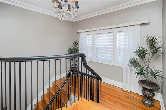 stairway with crown molding, baseboards, an inviting chandelier, and wood finished floors