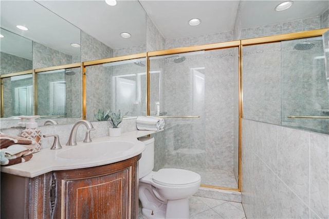 full bath featuring vanity, a stall shower, toilet, and tile walls