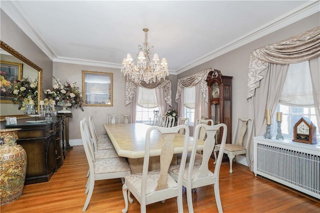 dining room with radiator heating unit, crown molding, wood finished floors, and a notable chandelier