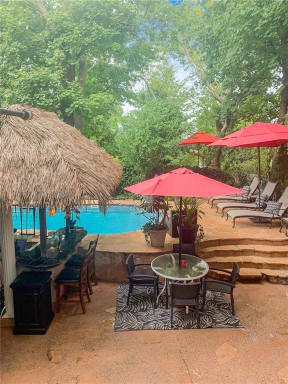 pool with a wooden deck and a patio