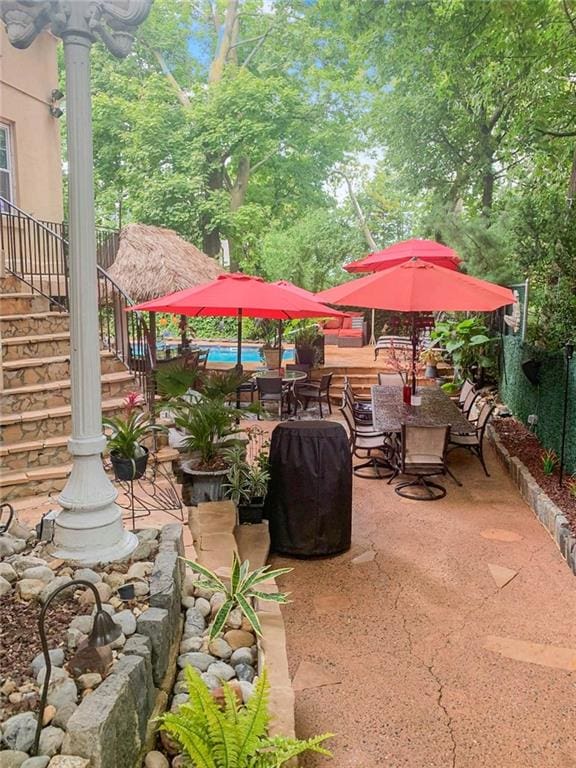 view of patio / terrace featuring fence, stairway, and an outdoor pool