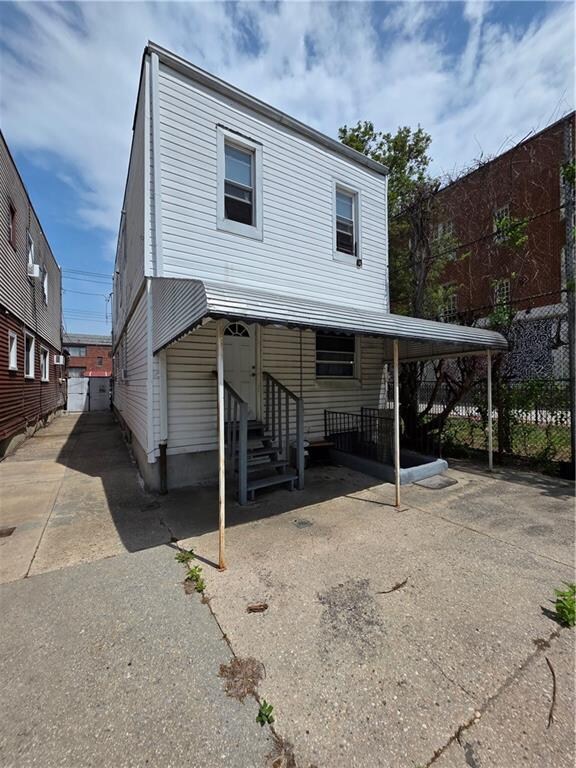 1462 E 92nd St, Brooklyn, NY 11236 - rear view of house featuring entry steps, asphalt driveway, and fence