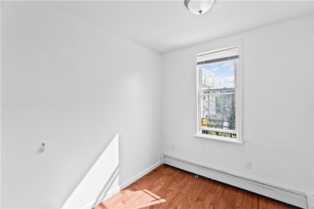 1462 E 92nd St, Brooklyn, NY 11236 - empty room featuring a baseboard heating unit, wood finished floors, and baseboards