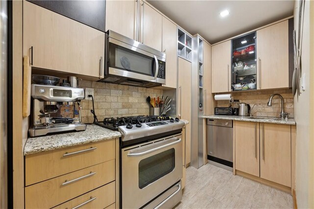 2800 Coyle St Unit 318, Brooklyn, NY 11235 - kitchen with light brown cabinetry, appliances with stainless steel finishes, decorative backsplash, and a sink