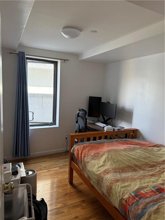 bedroom with light wood-style flooring and baseboards