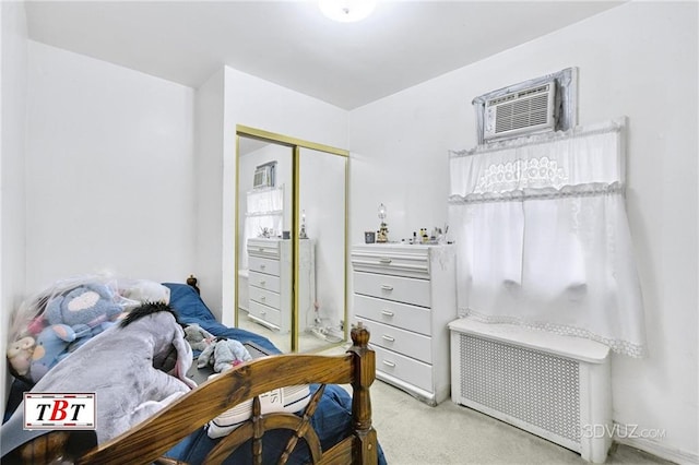 carpeted bedroom with radiator, a closet, and a wall unit AC