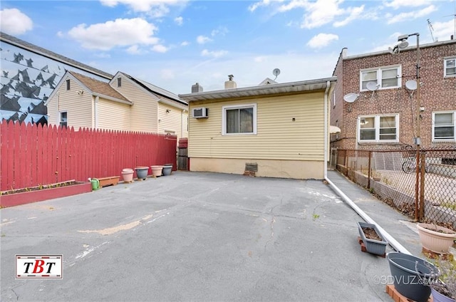 rear view of house with a patio, fence, and a wall mounted AC