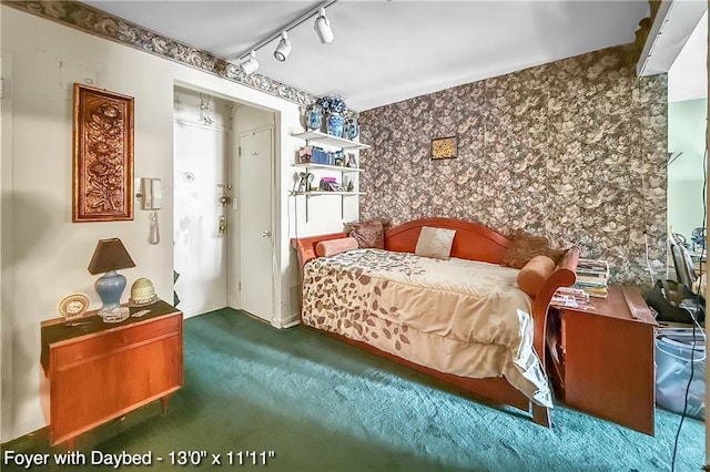 bedroom featuring carpet, rail lighting, and wallpapered walls