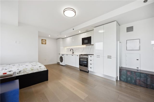 623 H Ave Unit 7C, New York, NY 11230 - bedroom with washer / dryer, light wood-style floors, a sink, recessed lighting, and baseboards